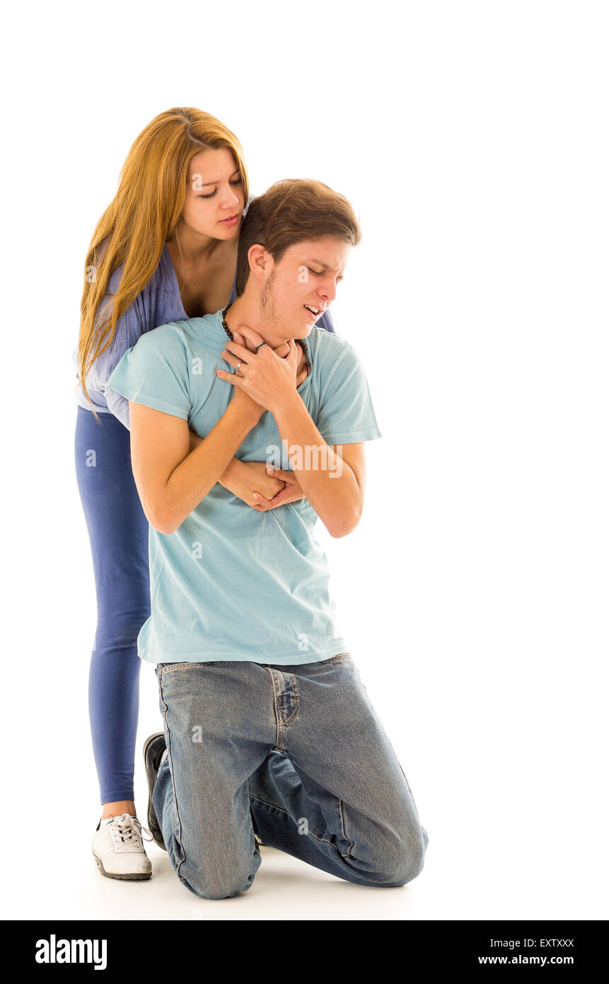 Couple demonstrating first aid techniques with woman performing heimlich on choking male Stock Photo
