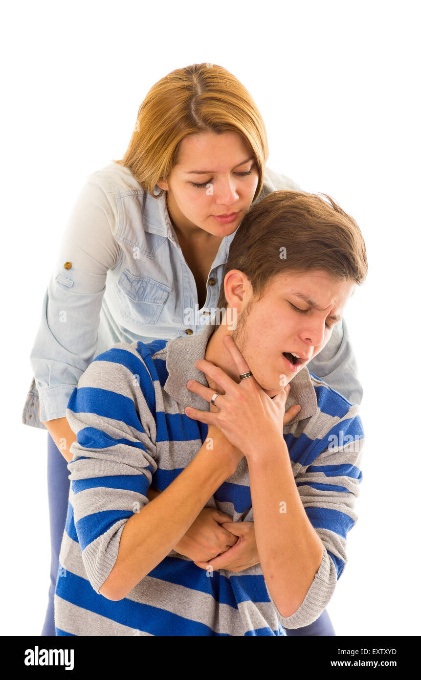 Couple demonstrating first aid techniques with woman performing heimlich in male choking Stock Photo