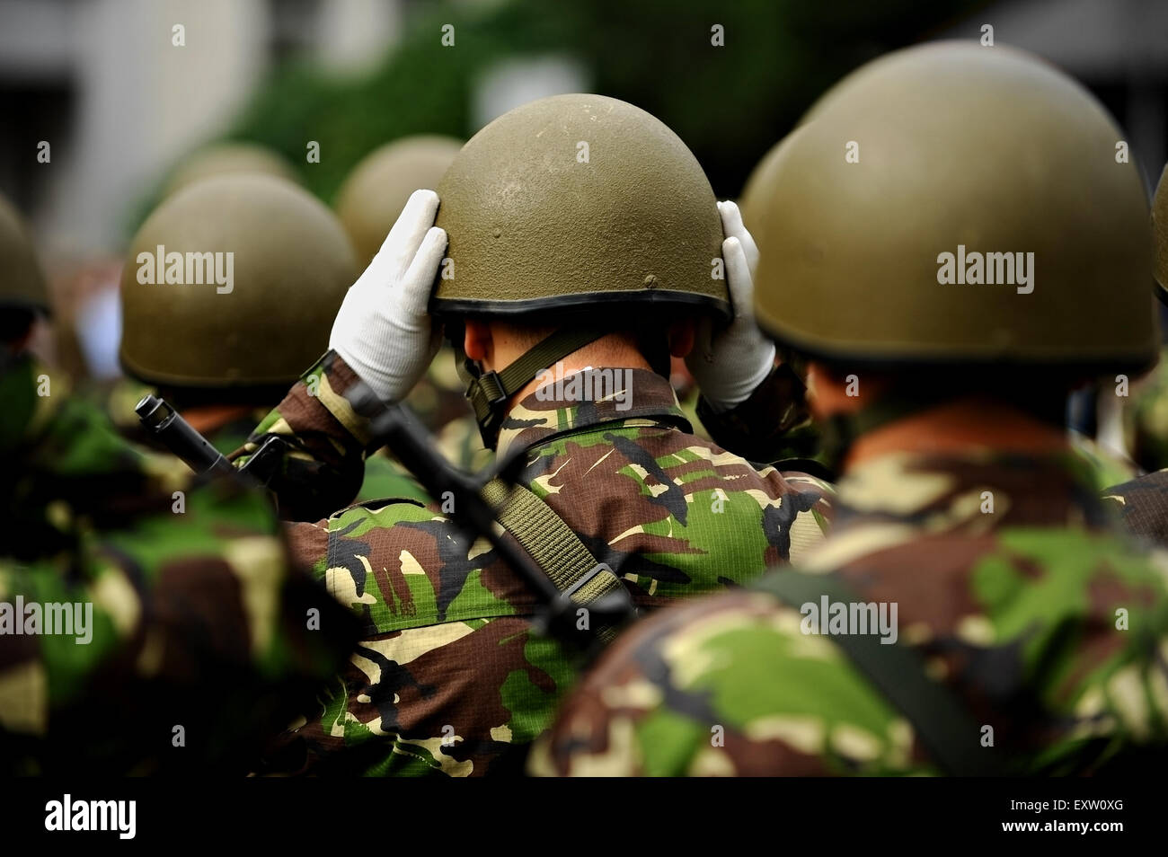 Group of unrecognizable soldiers in camouflage uniform with one ...
