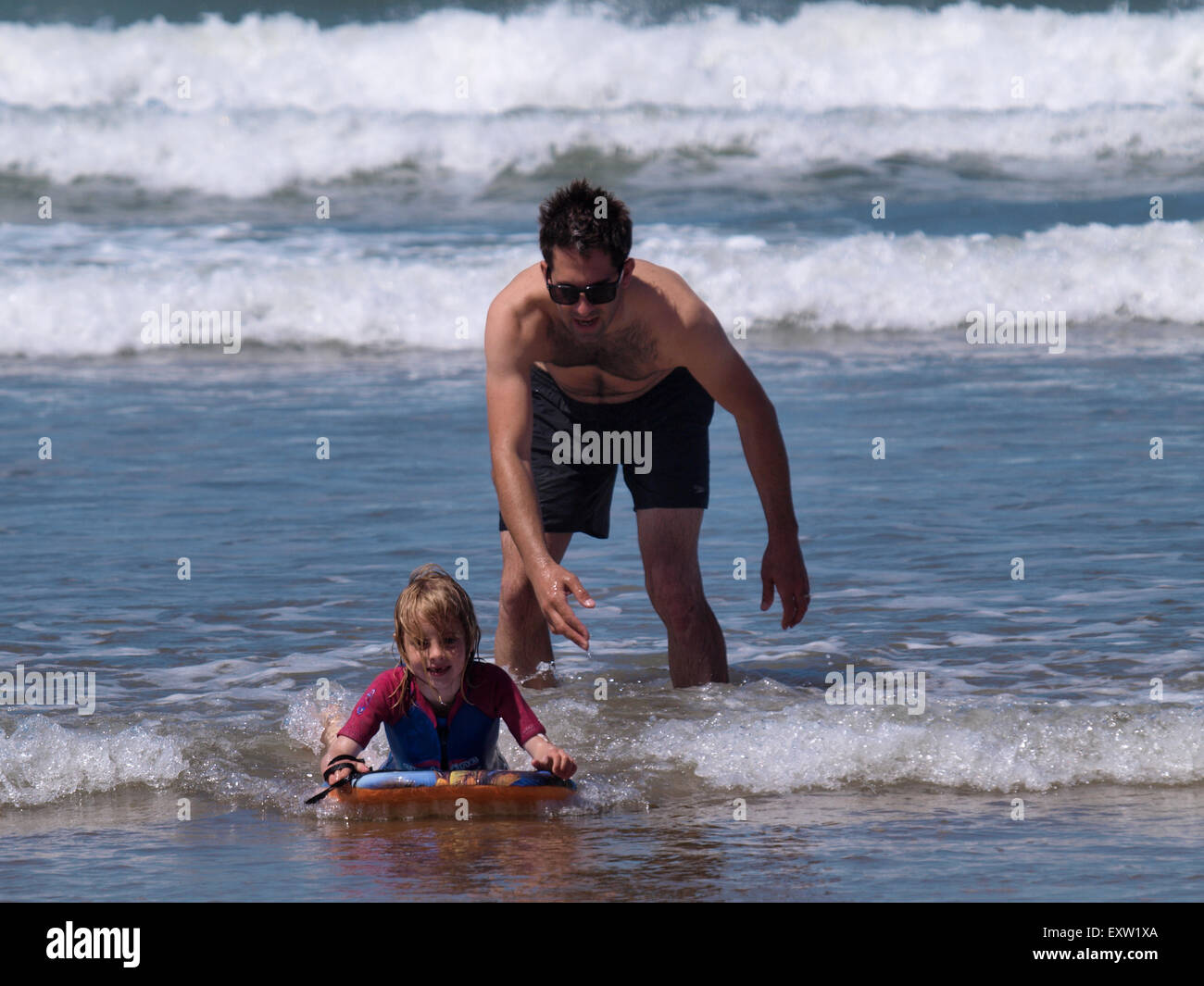 Father teaching daughter to bodyboard, Woolacombe, Devon, UK Stock Photo