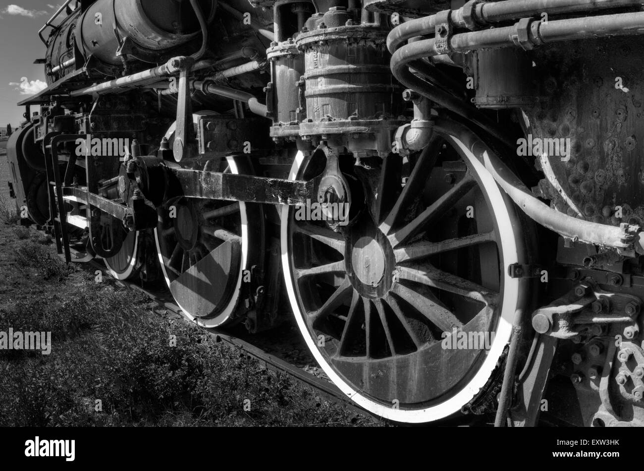 A monochrome image of a steam locomotive featuring the driving wheels Stock Photo