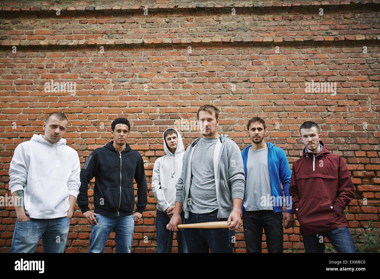 Group of hooligans or rappers on background of brick wall Stock Photo