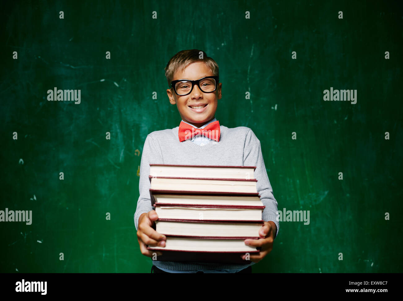 Happy schoolboy with stack of books looking at camera Stock Photo - Alamy