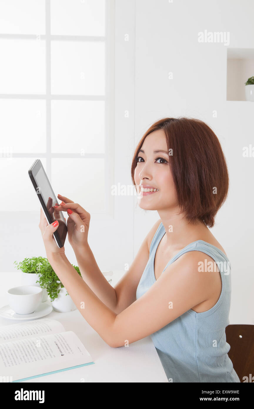 Young woman holding note pad and looking away with smile, Stock Photo