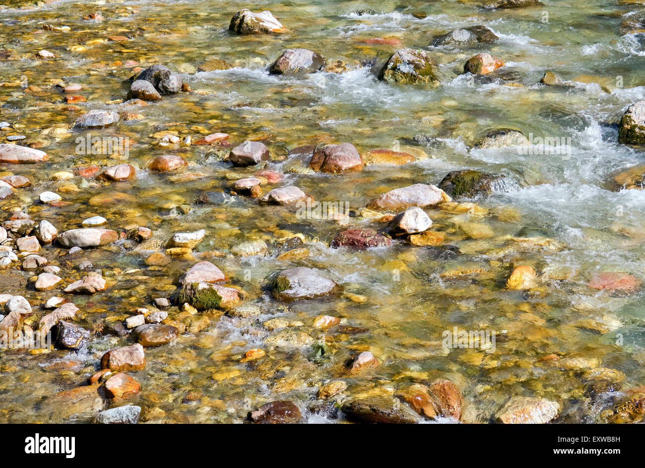 Closeup of clean water and rapids of the river with colorful stones Stock Photo