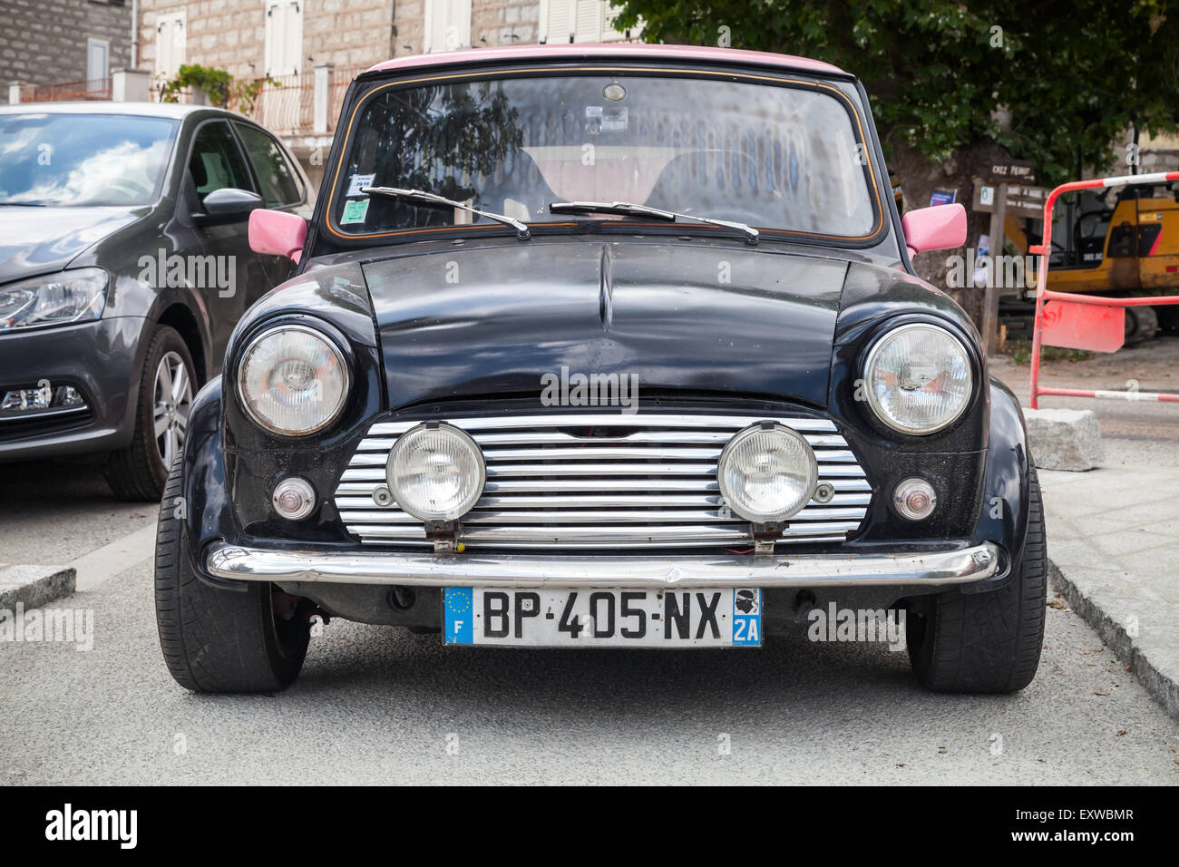 Quenza, France - July 1, 2015: Black Mini cooper car stands parked, closeup photo, front view Stock Photo