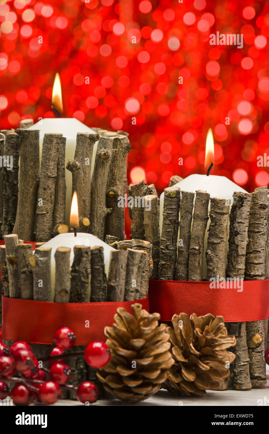 White candles in autumn winter decoration with real branch decoration Stock Photo