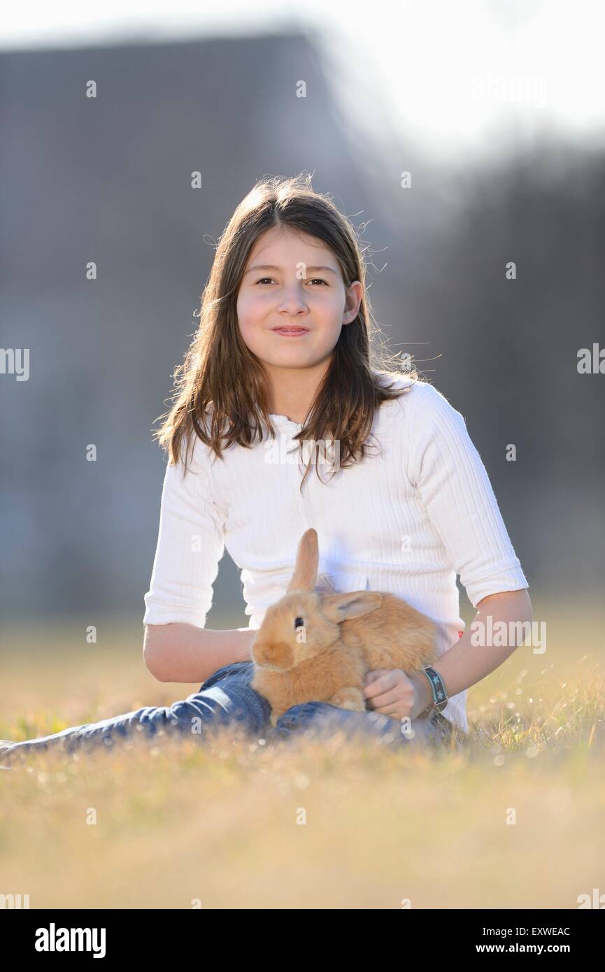 Teenage girl with her rabbit on a meadow, Upper Palatinate, Bavaria ...