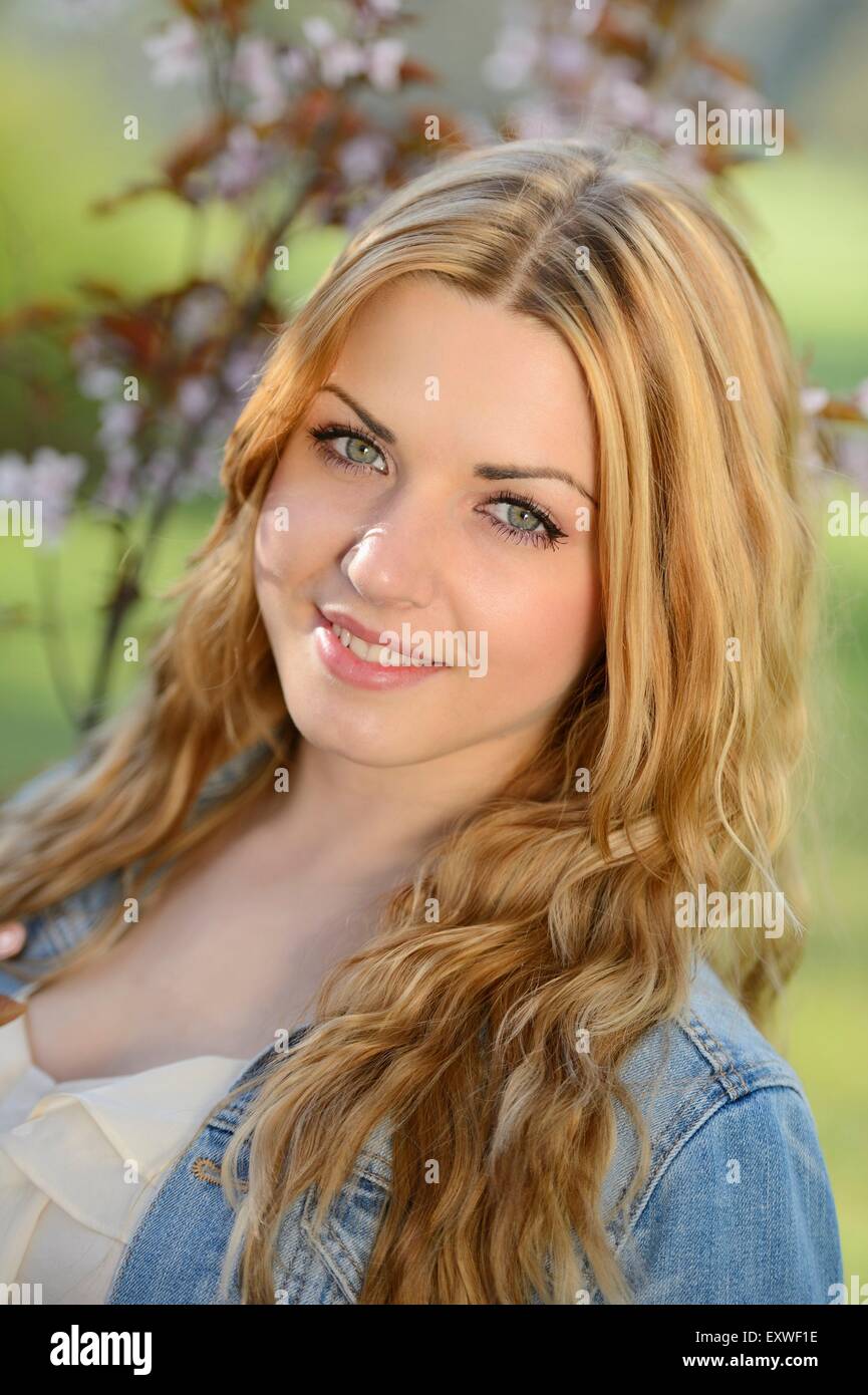 Young woman at blooming cherry tree, portrait Stock Photo - Alamy