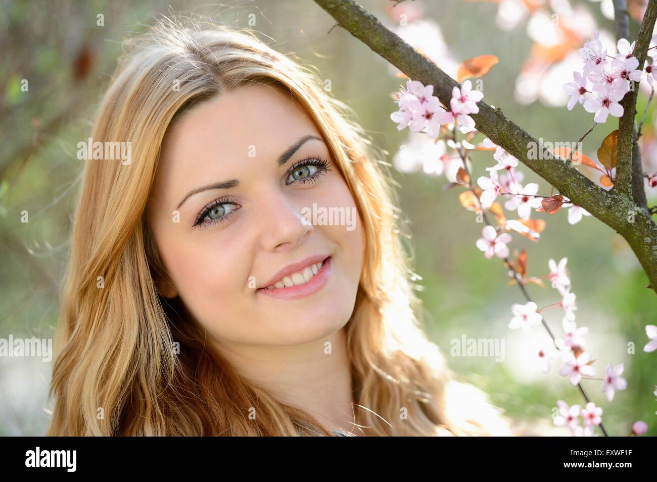 Young woman at blooming cherry tree, portrait Stock Photo - Alamy