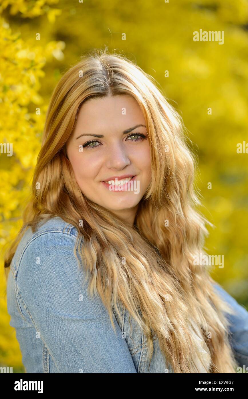 Young woman at blooming forsythia, portrait Stock Photo