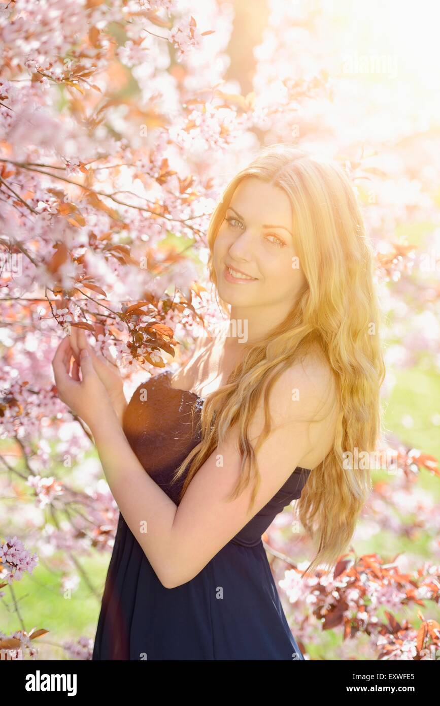 Young woman at blooming cherry tree, portrait Stock Photo - Alamy