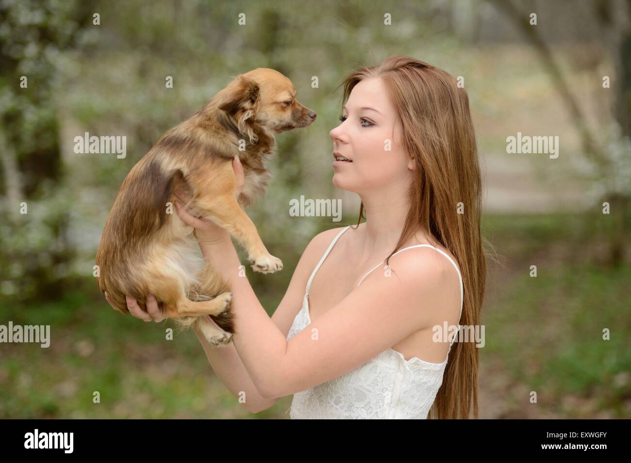 Young woman with a mixed breed dog puppy in garden Stock Photo