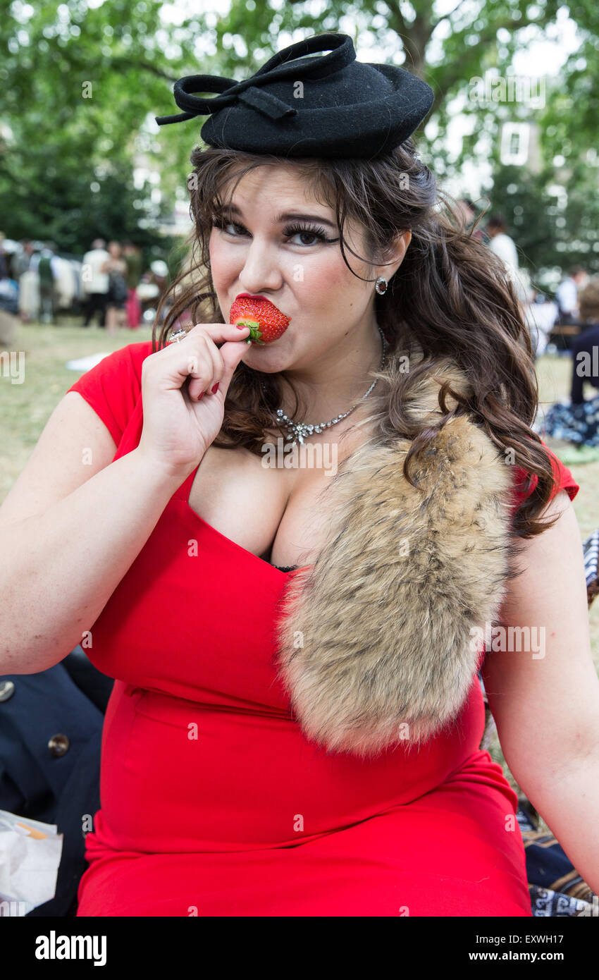 Woman wearing fox fur in1920s dress eating a strawberry Stock Photo