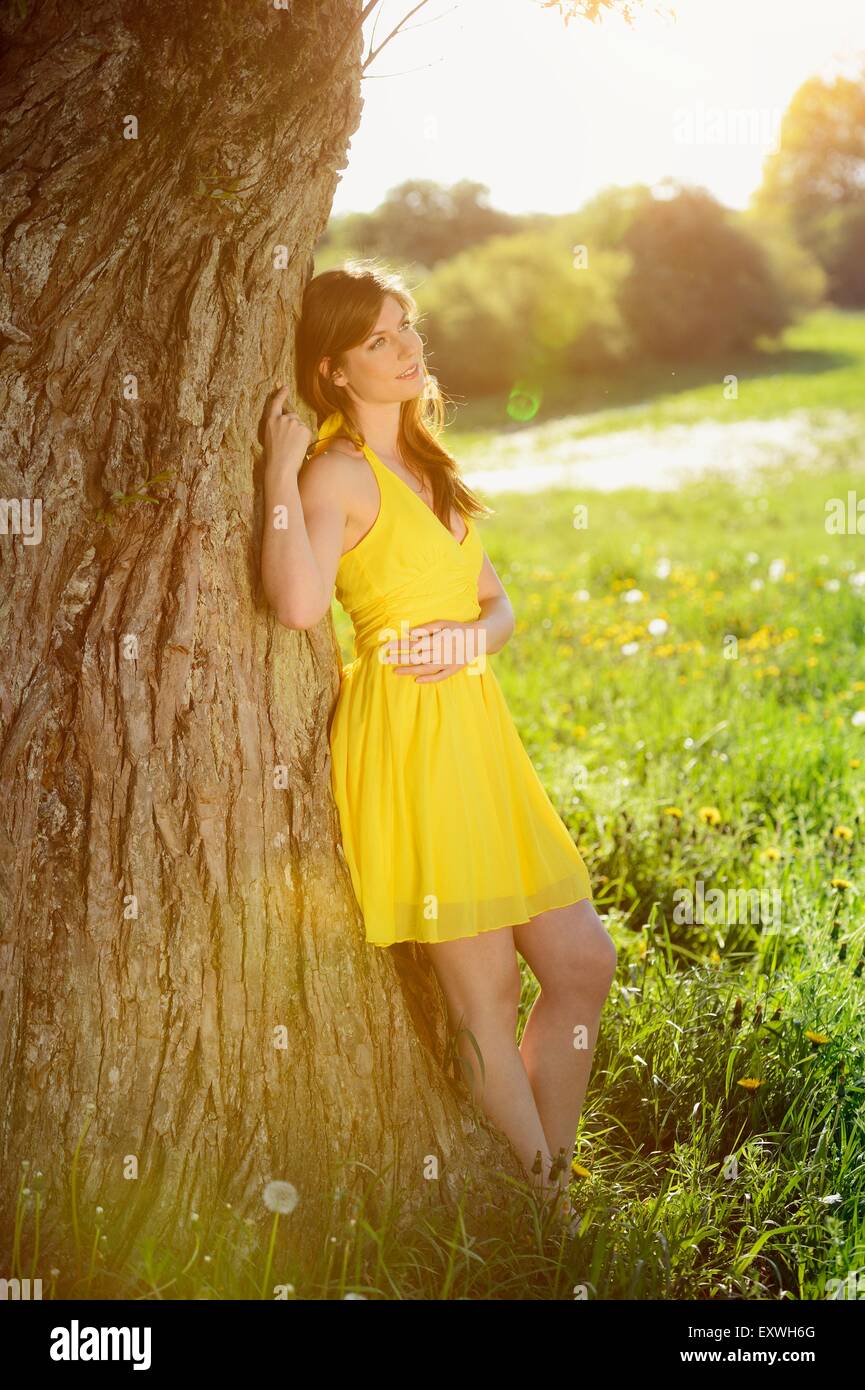Young woman at a tree, Bavaria, Germany, Europe Stock Photo