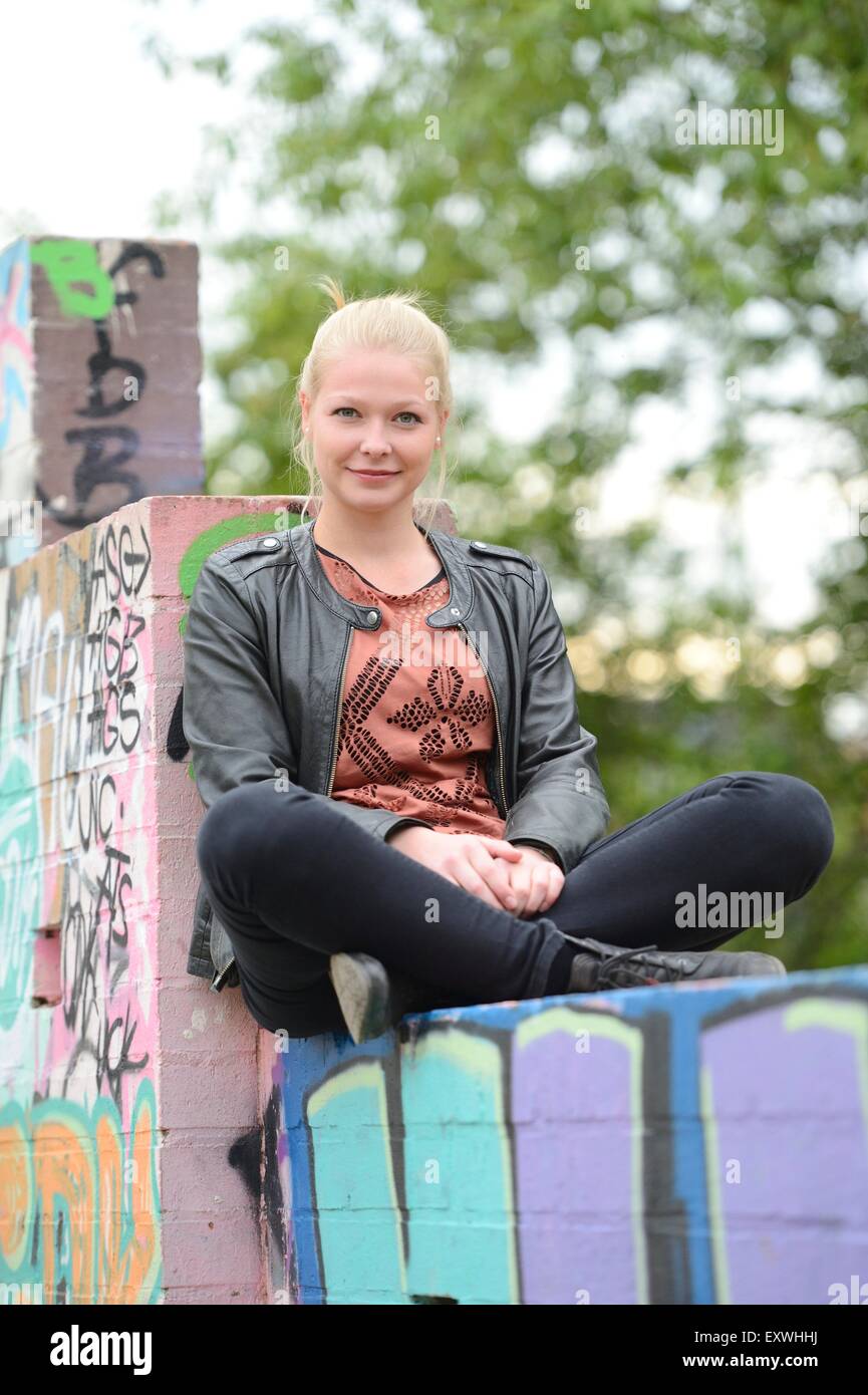 Young woman at a graffiti wall, Nuremberg, Bavaria, Germany, Europe Stock Photo