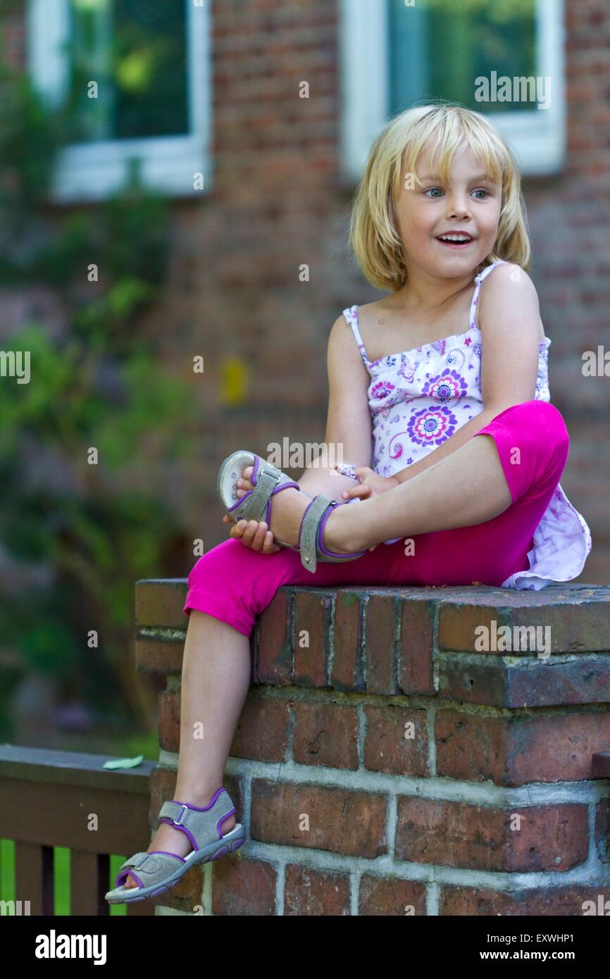 Girl sitting on a wall Stock Photo