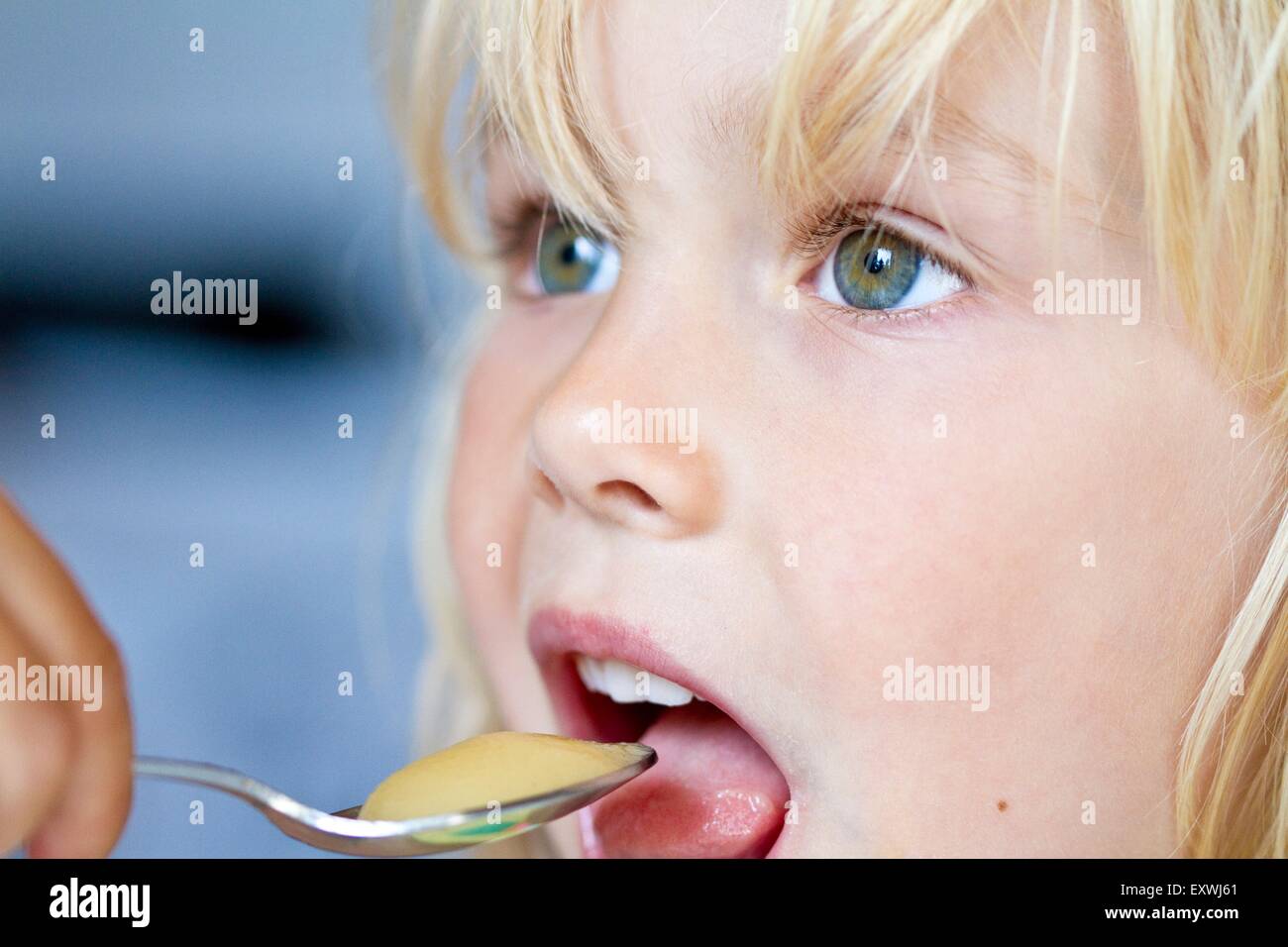 Girl eating with spoon Stock Photo Alamy