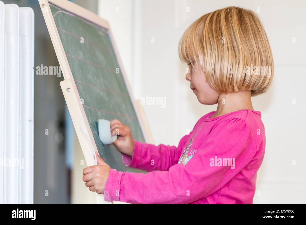 Girl playing school at blackboard Stock Photo