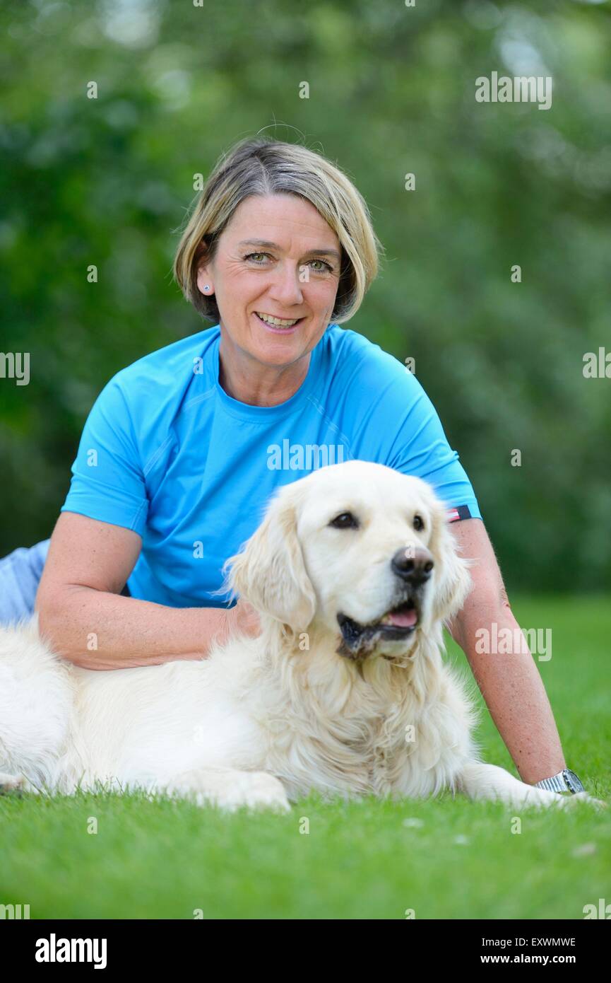 Mature woman with a golden retriever in garden Stock Photo