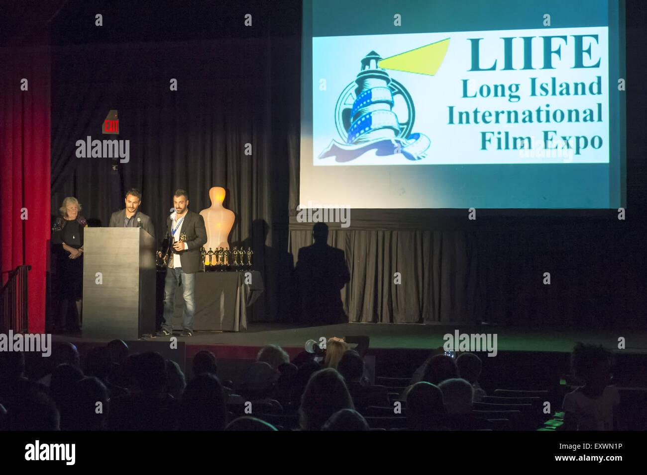 Bellmore, New York, USA. 16th July, 2015. L-R, Actress MARILYN CHRIS presents to filmmakers JORDAN HOROWITZ and FRANK FERENDO the Best Documentary Award for ANGEL OF NANJING during the LIIFE Awards Ceremony, at Bellmore Movies. The film is about Chen Si who has saved over 300 people from commiting suicide at the Yangtze River Bridge in Nanjing, the most popular place in the world to commit suicide. It was the 18th Annual Long Island International Film Expo. Credit:  Ann Parry/ZUMA Wire/Alamy Live News Stock Photo