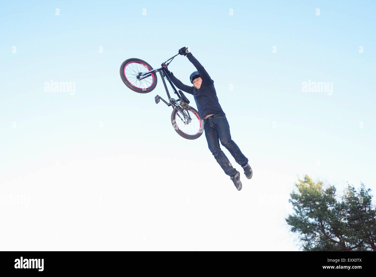 Teenager jumping in the air with his bmx bike Stock Photo