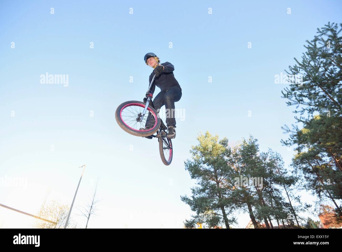 Teenager jumping in the air with his bmx bike Stock Photo