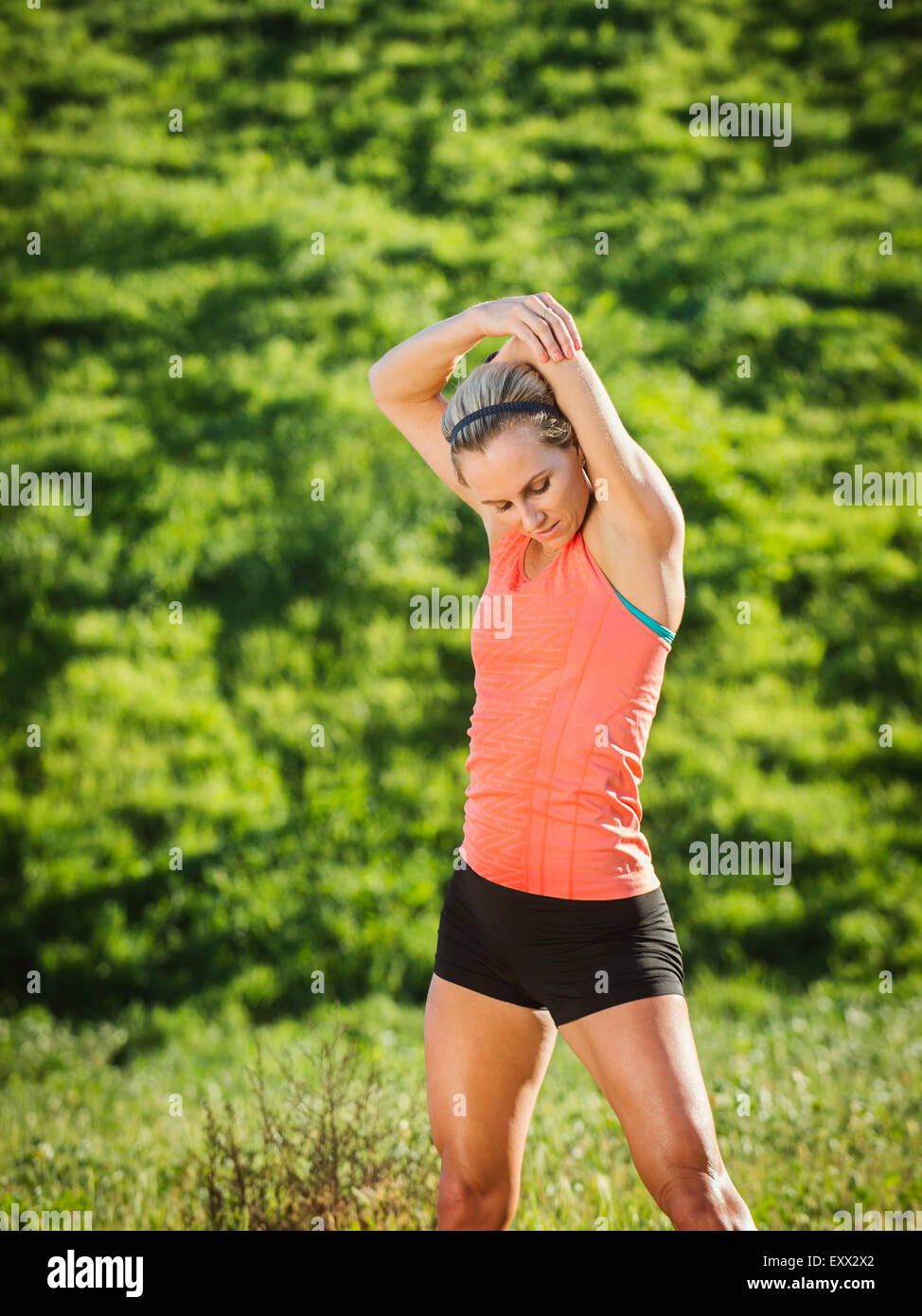 Woman exercising in field Stock Photo