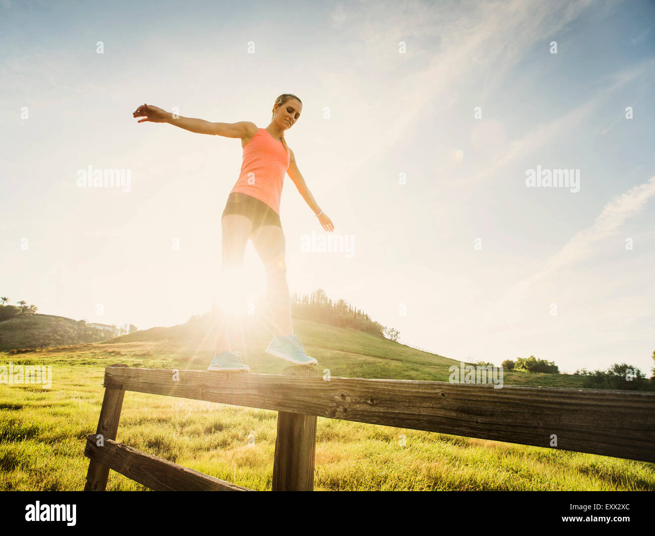 Woman balancing on wooden fence Stock Photo