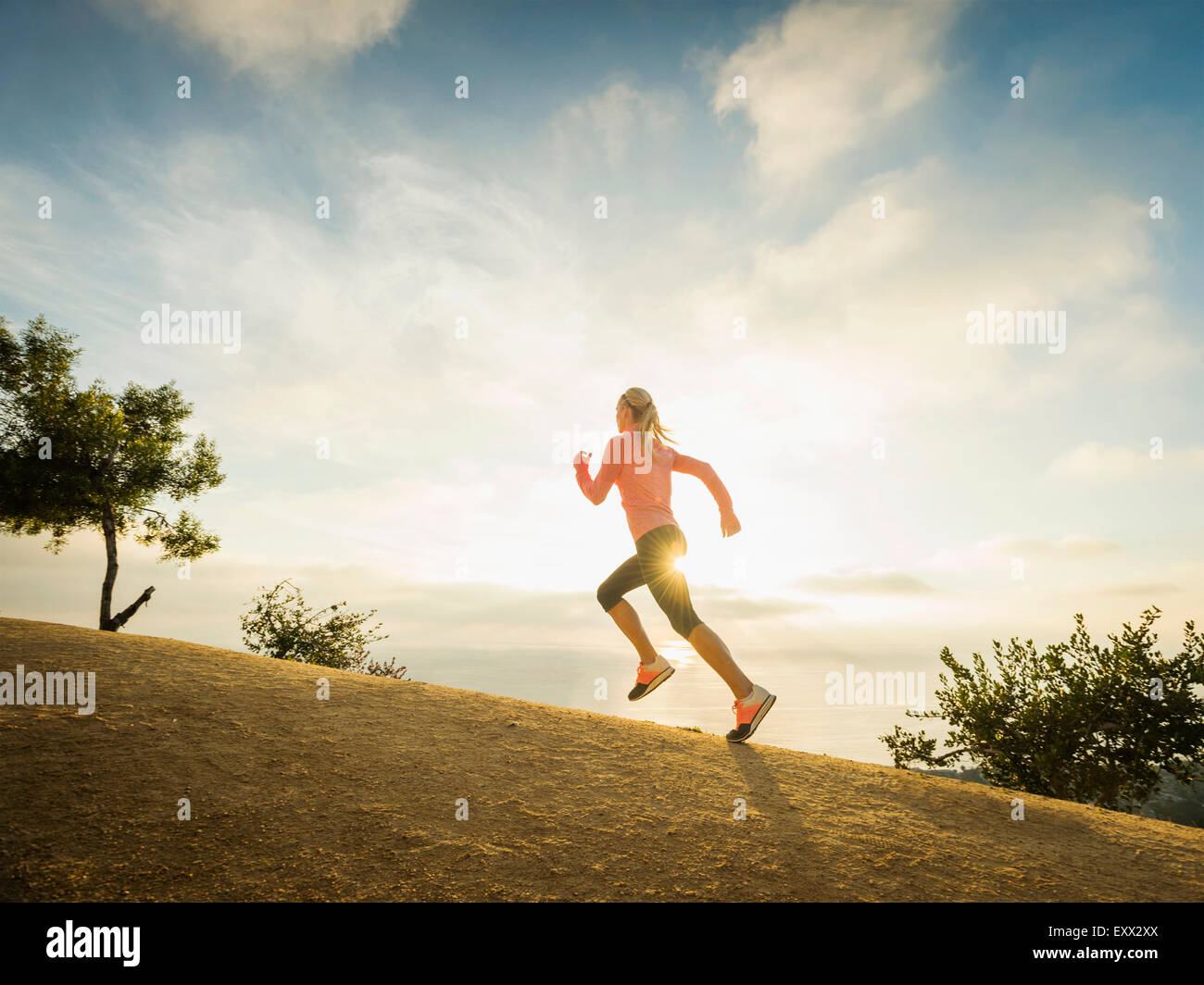 Woman running in mountains Stock Photo