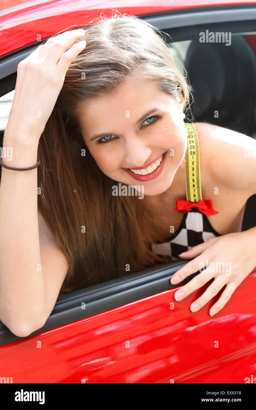 Portrait of smiling woman in red car Stock Photo