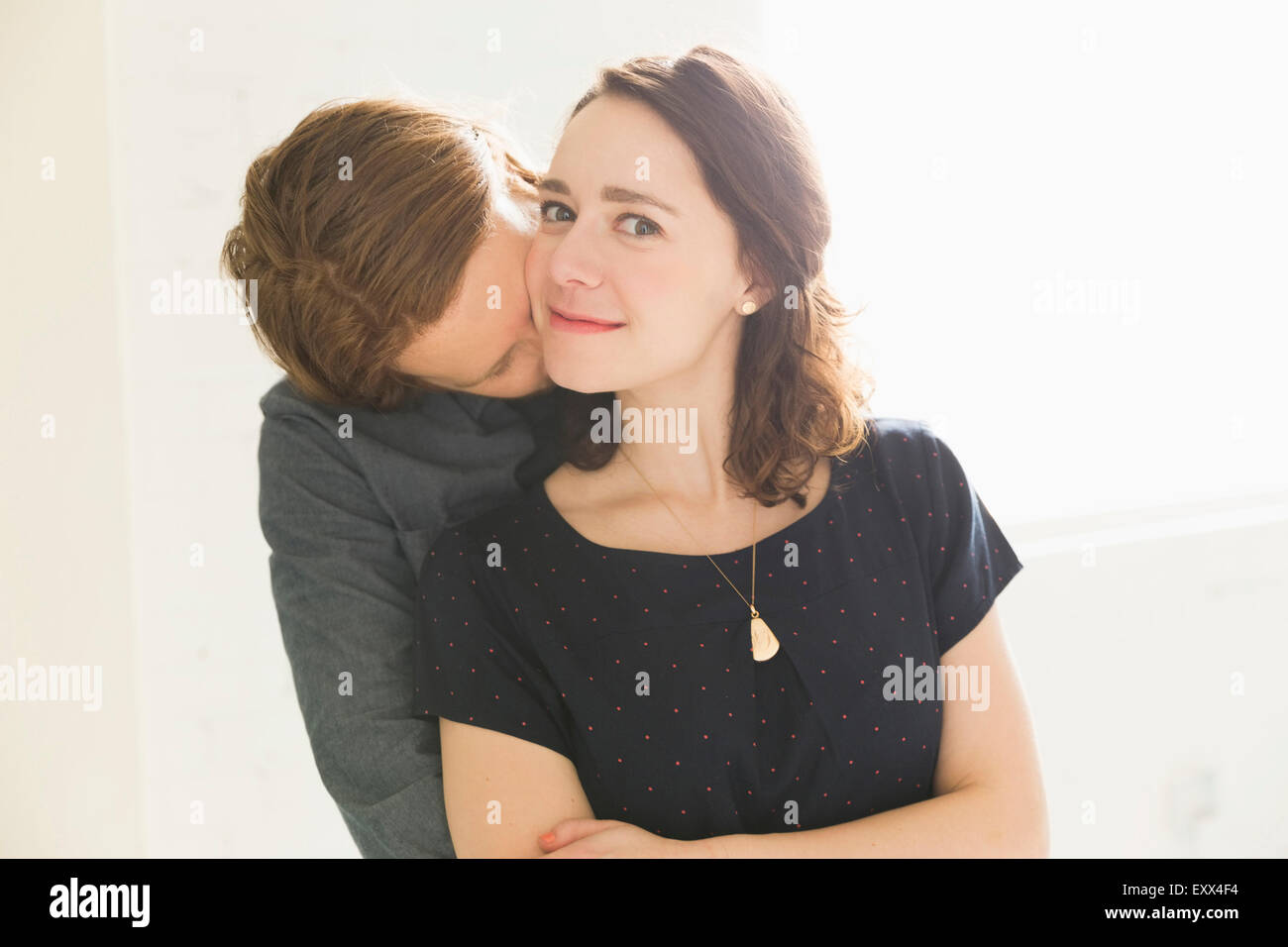 Man kissing smiling young woman Stock Photo - Alamy