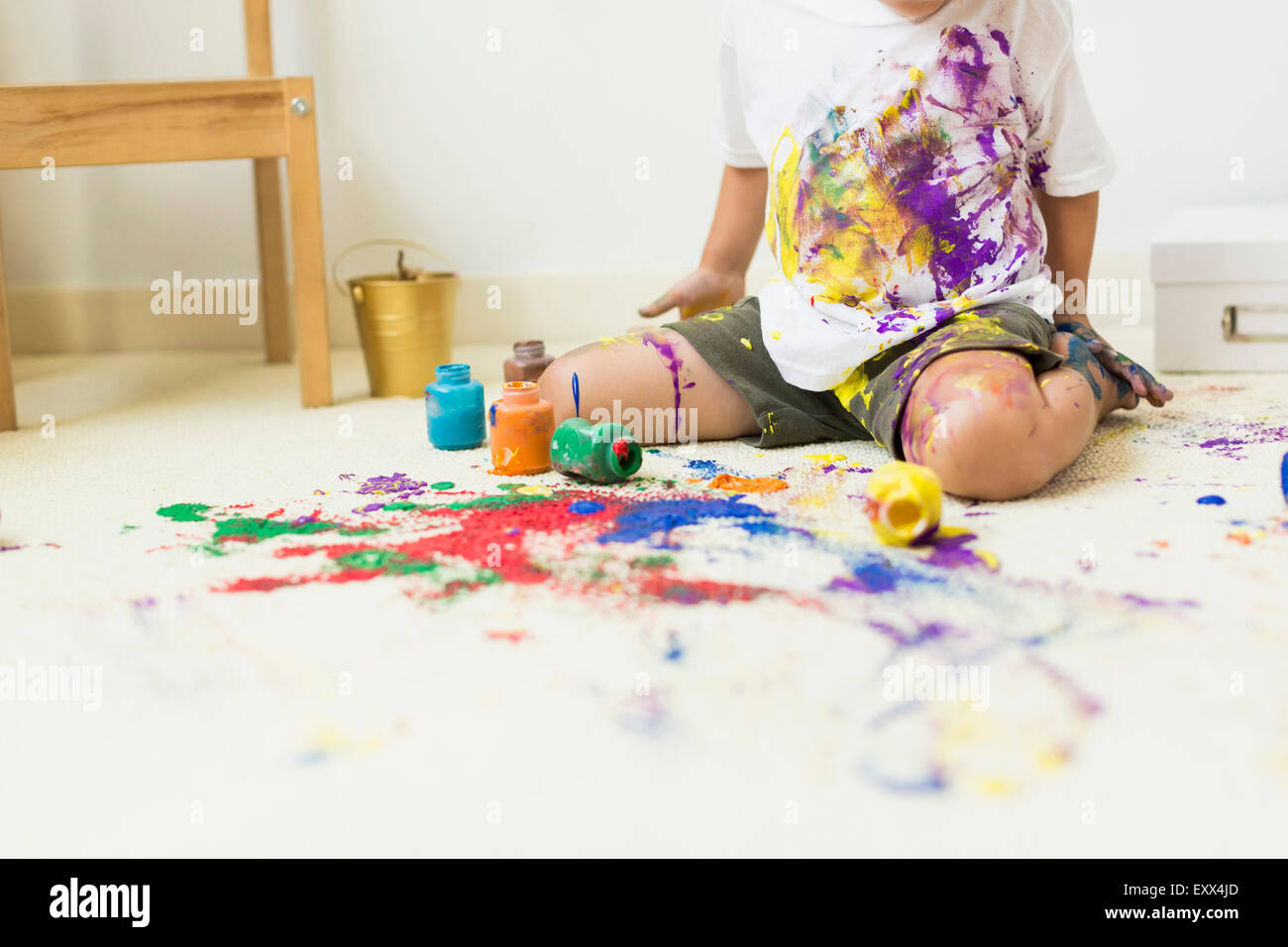 Boy (2-3) painting on carpet Stock Photo