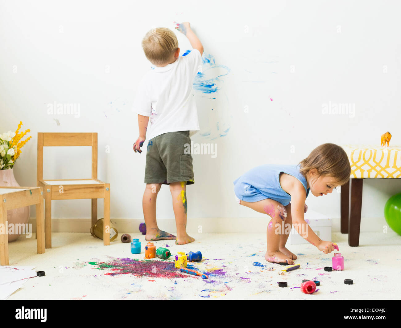 Children (2-3) painting on carpet and wall Stock Photo
