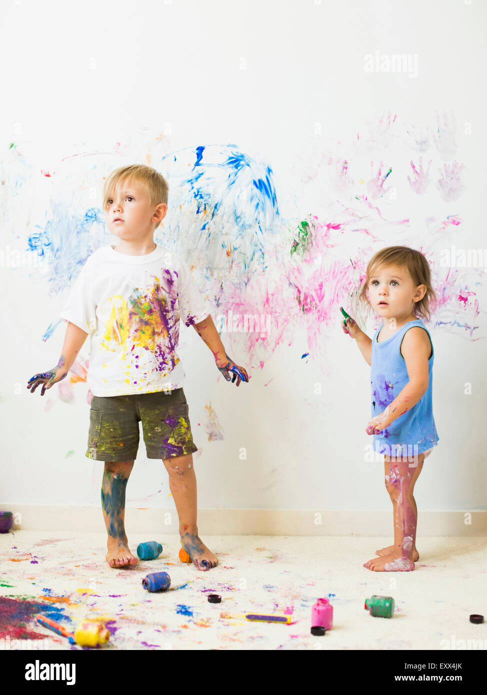 Children (2-3) painting on wall Stock Photo