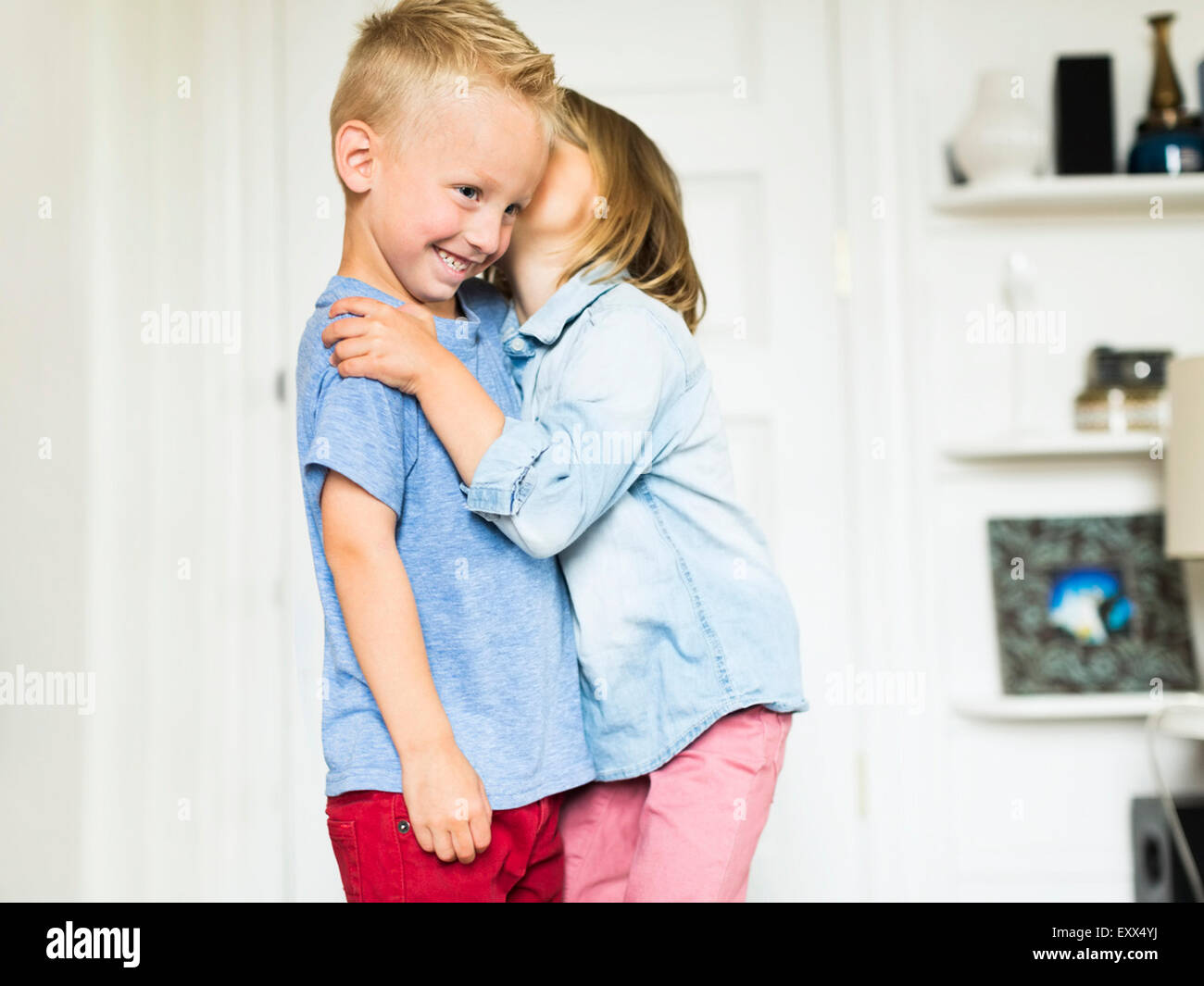 Little girl (45) whispering into brother's (45) ear Stock Photo Alamy
