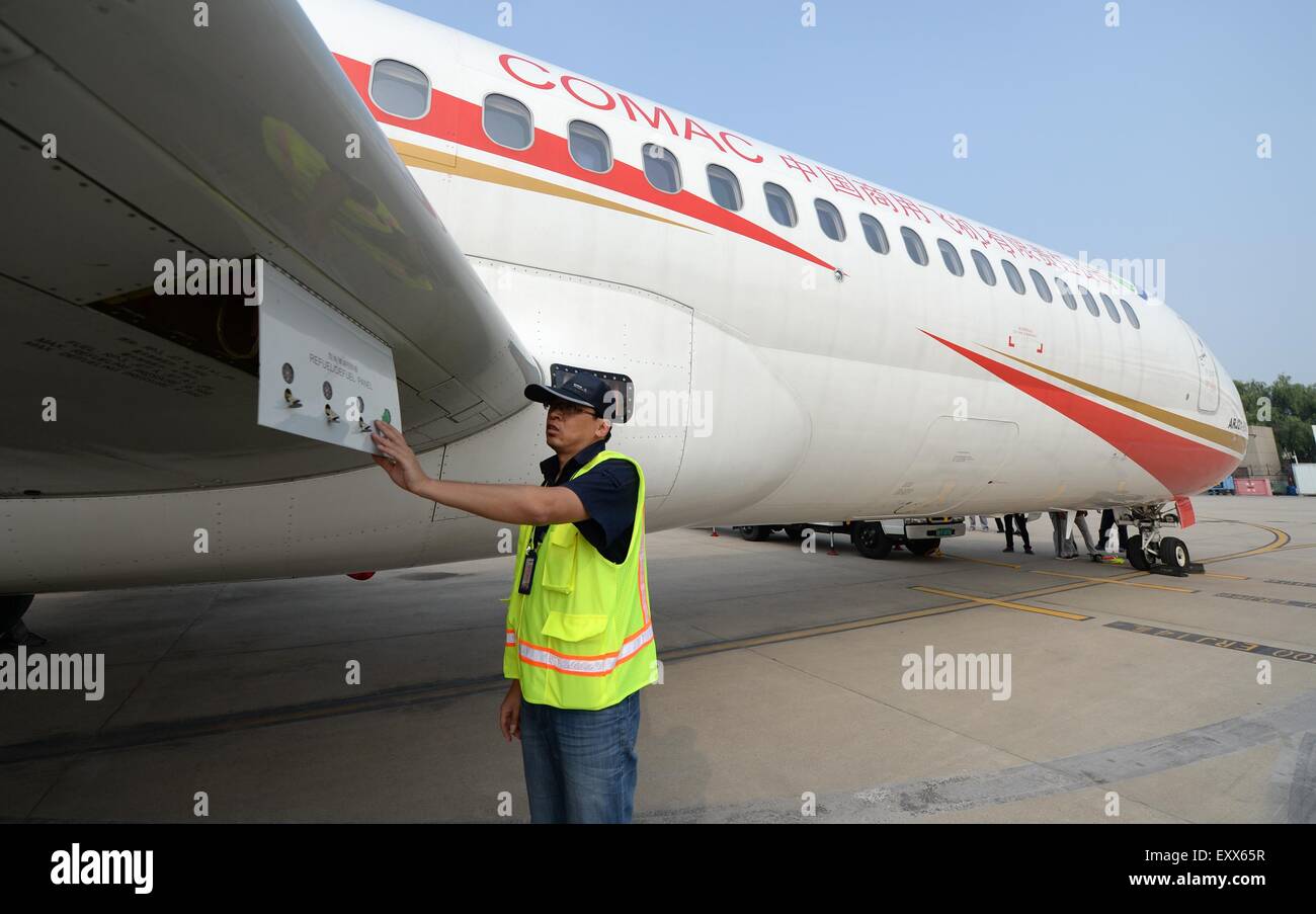 Xi'an, China's Shaanxi Province. 17th July, 2015. A ground crew member checks the ARJ21-700 jet after a demonstration flight in Xi'an, capital city of northwest China's Shaanxi Province, July 17, 2015. The ARJ21, short for Advanced Regional Jet for the 21st Century, is a type of regional airliner designed and manufactured by the Commercial Aircraft Corporation of China (COMAC). Over twenty representatives were invited on Friday to experience the one-hour demonstration flight and give feedbacks so as to help improve the overall performance of the jet. © Li Yibo/Xinhua/Alamy Live News Stock Photo