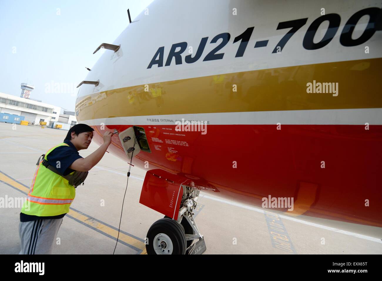 Xi'an, China's Shaanxi Province. 17th July, 2015. A ground crew member checks the ARJ21-700 jet after a demonstration flight in Xi'an, capital city of northwest China's Shaanxi Province, July 17, 2015. The ARJ21, short for Advanced Regional Jet for the 21st Century, is a type of regional airliner designed and manufactured by the Commercial Aircraft Corporation of China (COMAC). Over twenty representatives were invited on Friday to experience the one-hour demonstration flight and give feedbacks so as to help improve the overall performance of the jet. © Li Yibo/Xinhua/Alamy Live News Stock Photo
