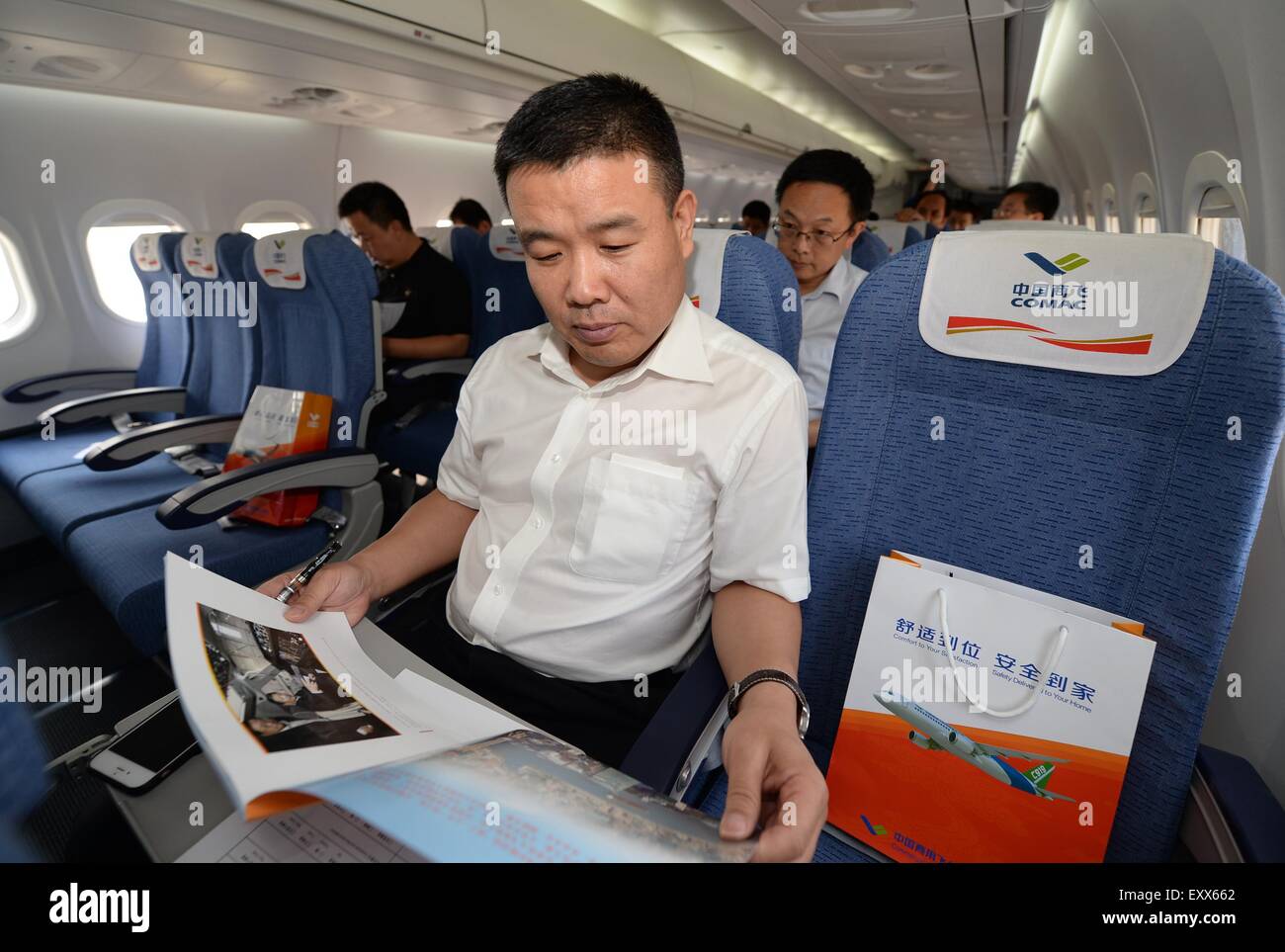 Xi'an, China's Shaanxi Province. 17th July, 2015. Passengers experience a demonstration flight of the ARJ21-700 jet in Xi'an, capital city of northwest China's Shaanxi Province, July 17, 2015. The ARJ21, short for Advanced Regional Jet for the 21st Century, is a type of regional airliner designed and manufactured by the Commercial Aircraft Corporation of China (COMAC). Over twenty representatives were invited on Friday to experience the one-hour demonstration flight and give feedbacks so as to help improve the overall performance of the jet. © Li Yibo/Xinhua/Alamy Live News Stock Photo