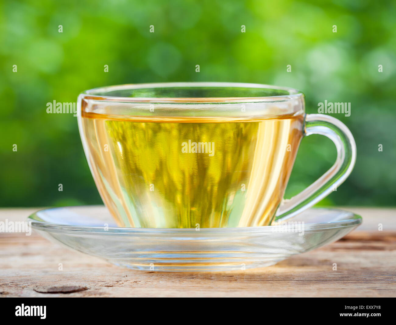 https://c8.alamy.com/comp/EXX7Y8/tea-cup-on-wooden-table-green-background-EXX7Y8.jpg