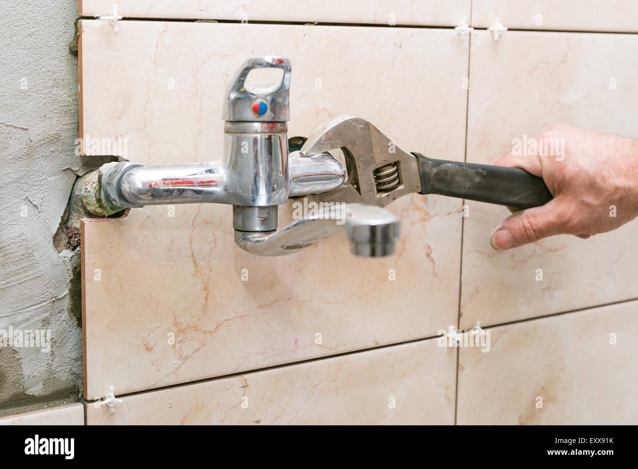Plumber hands fixing water tap with spanner Stock Photo Alamy