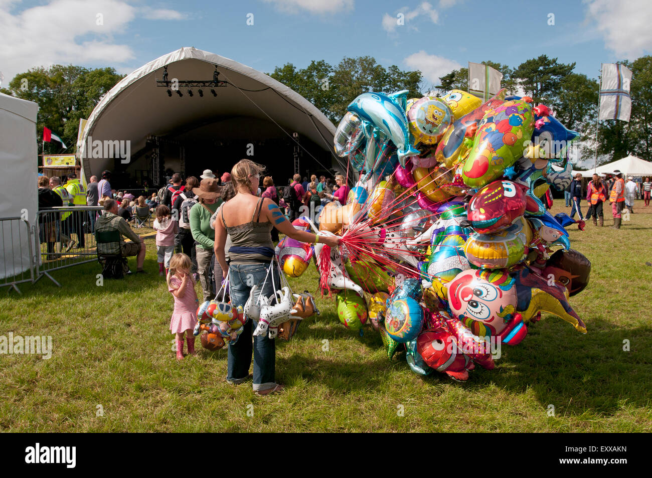 A woman selling balloons from a huge bunch of balloons at the WOMAD world music festival Stock Photo
