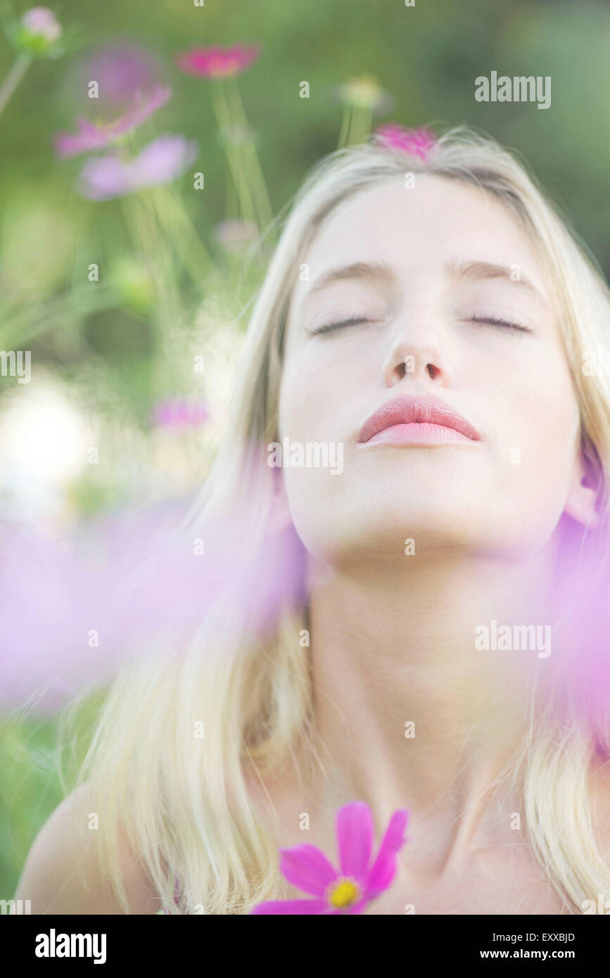 Woman overwhelmed by the sweet fragrence of blooming flowers Stock Photo