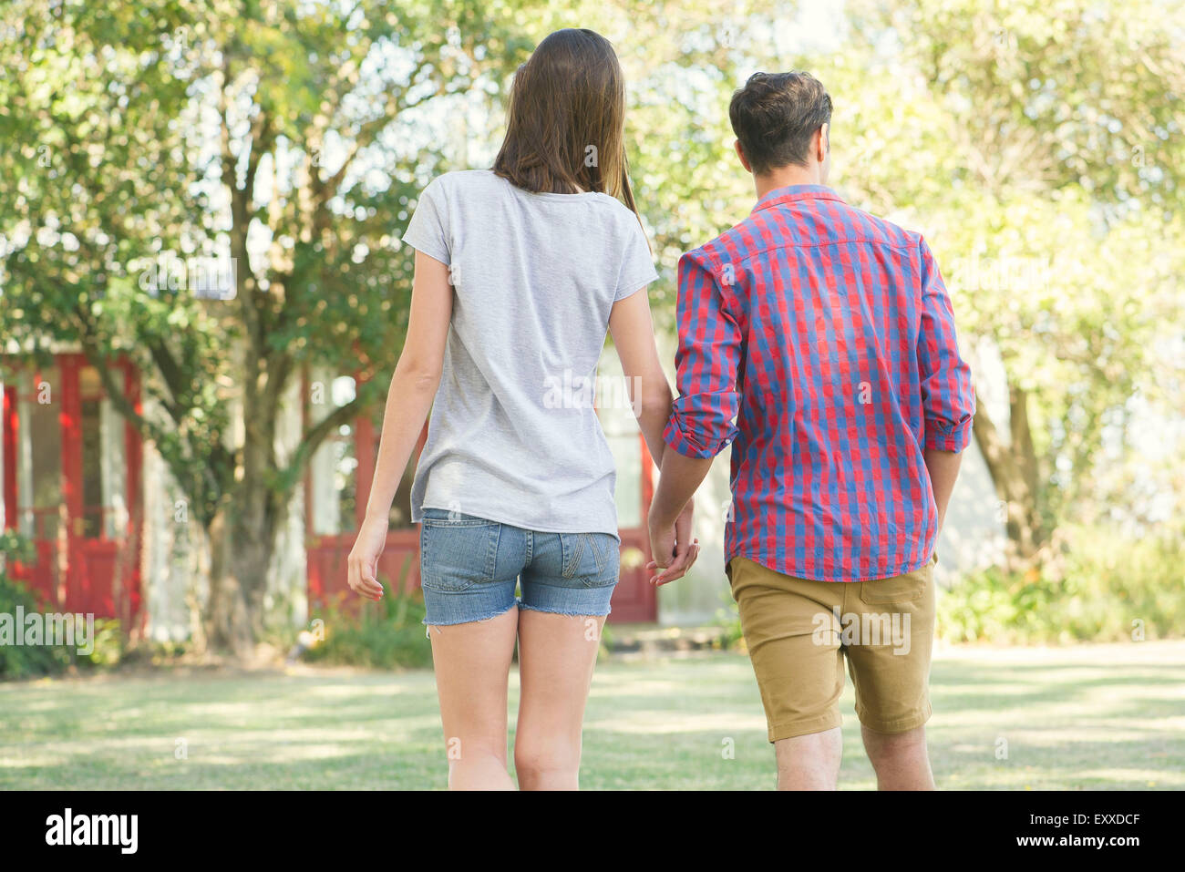 Couple walking and holding hands outdoors, rear view Stock Photo - Alamy