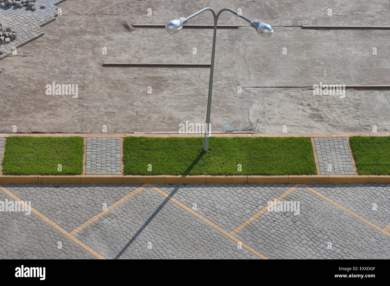Pavement parking lot construction with green grass and street lamp