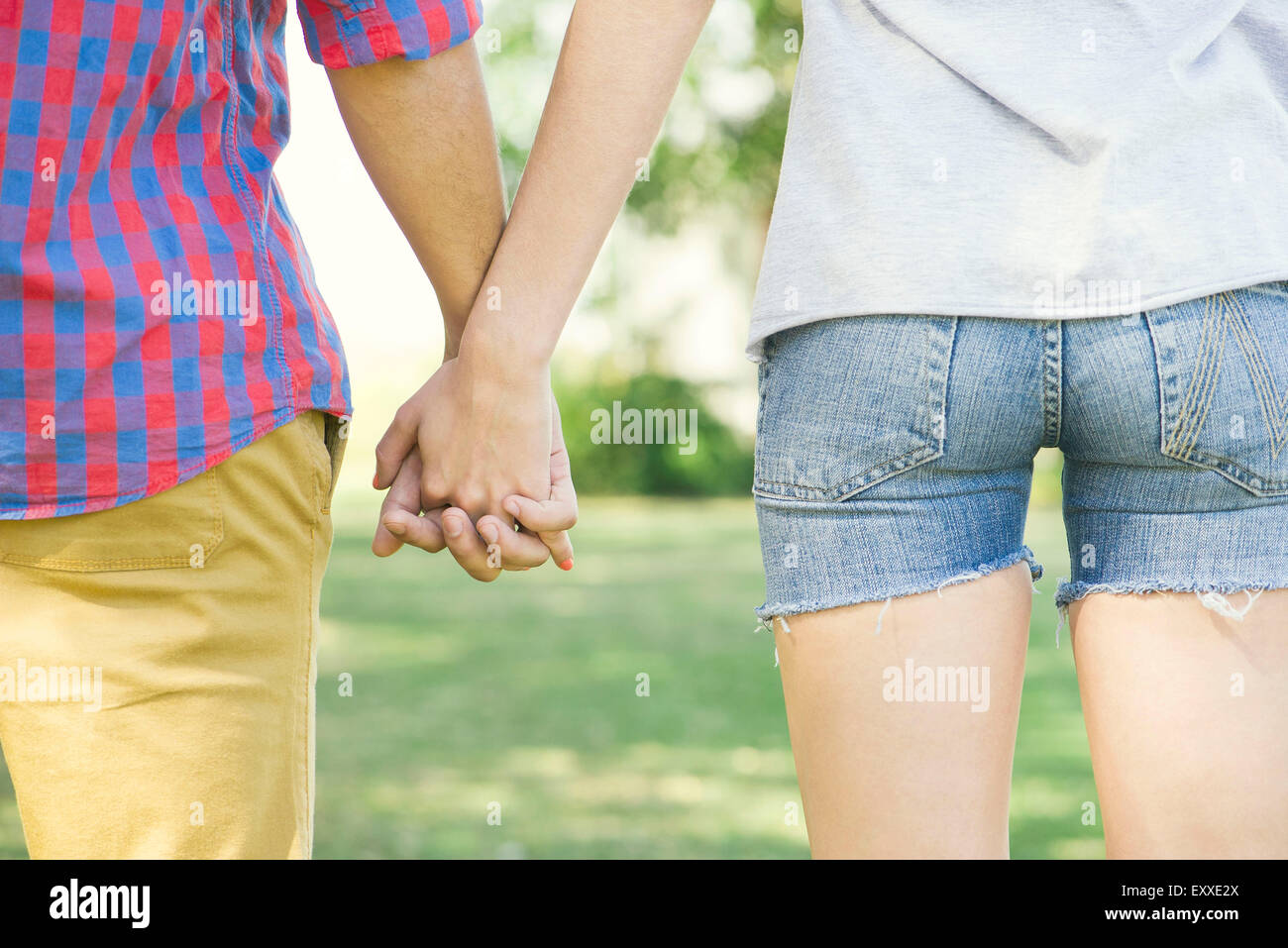 Couple holding hands outdoors, cropped rear view Stock Photo - Alamy