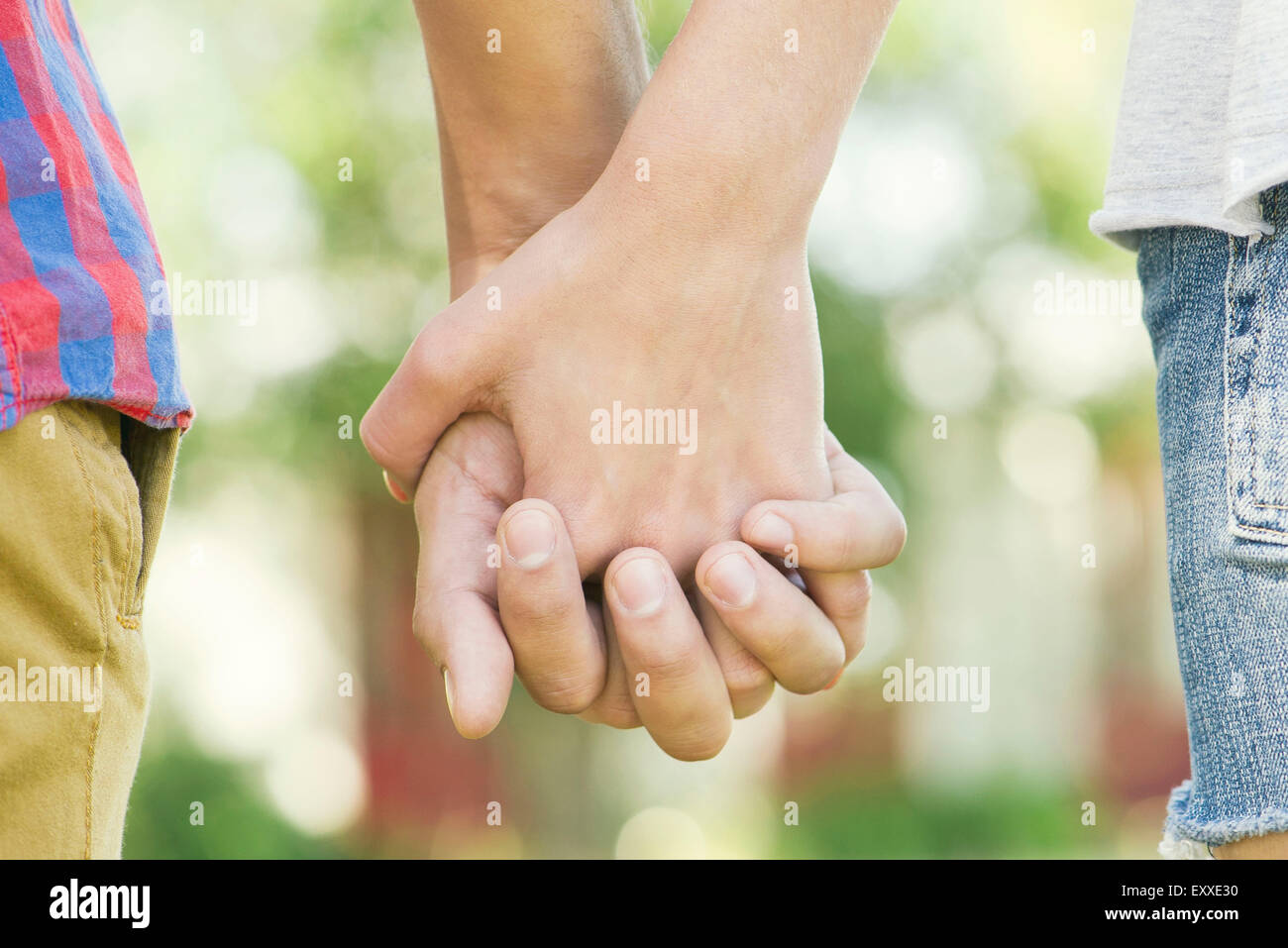 Couple holding hands outdoors, cropped rear view Stock Photo - Alamy