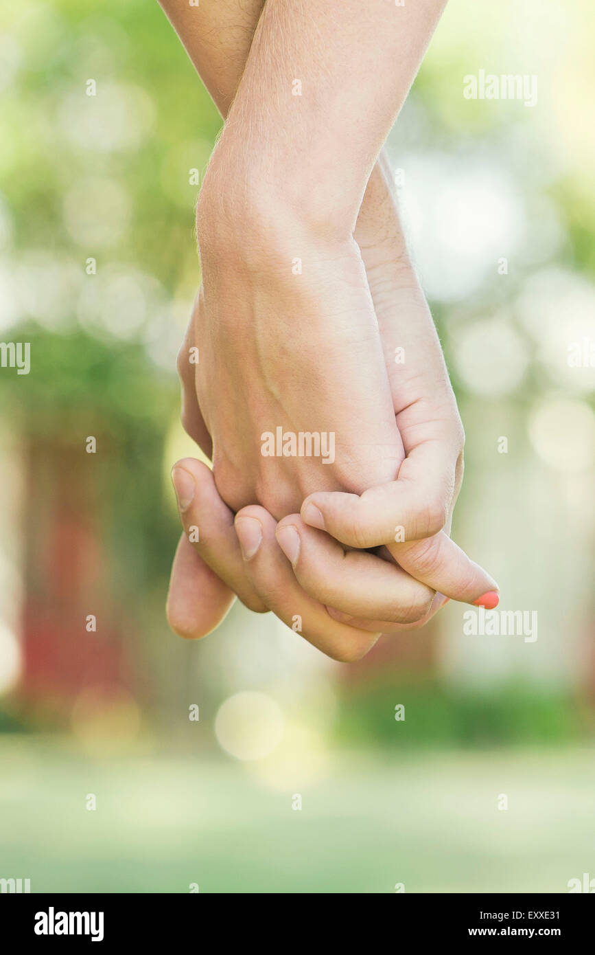 Couple holding hands outdoors, cropped rear view Stock Photo - Alamy