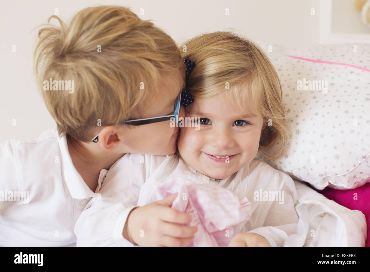 Boy kissing little sister's cheek Stock Photo
