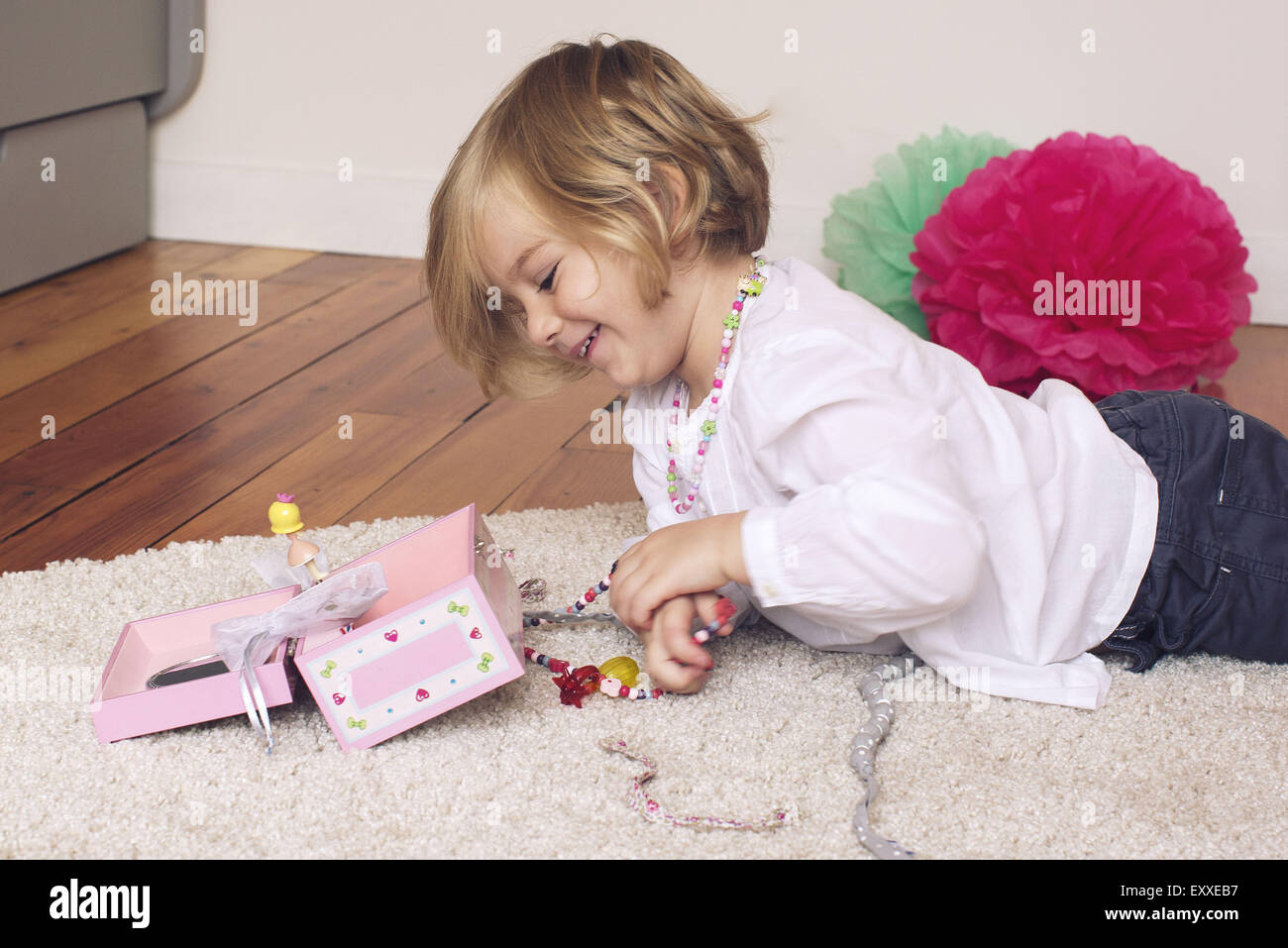 Little girl removing necklace from jewellery box Stock Photo